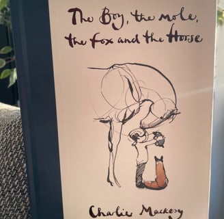 a book with a drawing of a boy, a mole, a horseand and a  cat