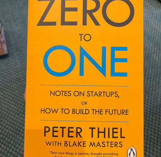 a person holding a book about zero to one