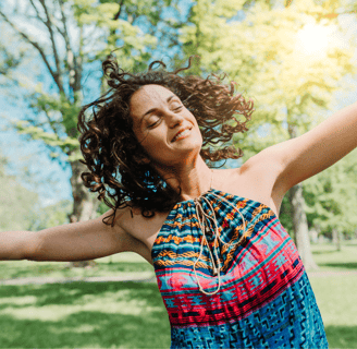 a woman with her arms outstretched out and arms outstretched out, smiling and holding a