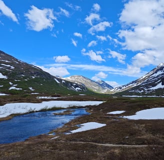Snow scattered on top of mountains with lake