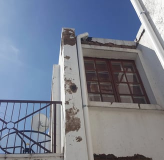 Weather-Exposed External Wall with Moisture and Plaster Erosion