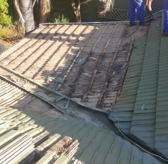 Non-compliant roof showing exposed battens and deteriorated waterproofing.