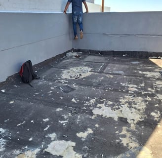 Flat roof with membrane peeling from UV exposure and thermal movement cracks