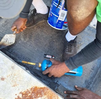 Setting of torch on bitumen with troweling tool, Scottburgh Mall, South Coast, Amanzimtoti