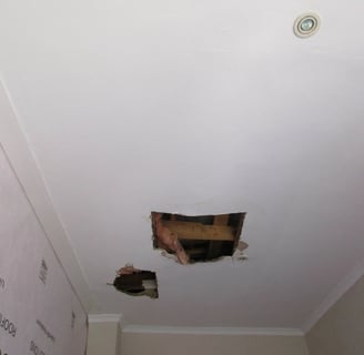 Hole in ceiling showing roof board failure