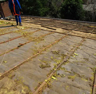 Old tile roof stripped down, showing deteriorated battens and perished underlay on a West Rand roof