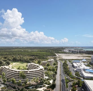 Luxury coastal resort with wave-like buildings, lush greenery, pools, a golf course, and ocean view.