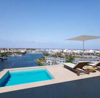 a pool with a lounge chair and a view of the ocean