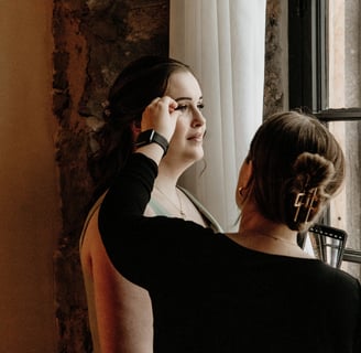 Makeup artist adjusting a bridesmaid’s false lashes.