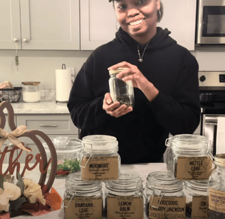 a woman in a black hoodie and a jar of tea