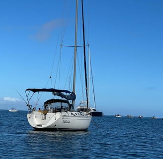 a sailboat in the water with a boat in the background