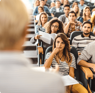a man and woman sitting listening to a someone speak