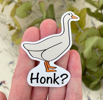 a person holding a sticker with a goose on it