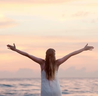 una mujer con brazos abiertos mirando al horizonte