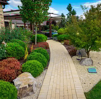 a walkway with a brick walkway and a stone path