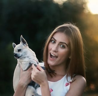 A woman holding a white puppy