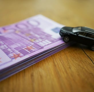 Schulz & Partner Stapel mit 500 Euro Schienen und Spielzeugauto