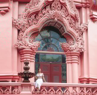 a woman in a white dress sitting on a balcony