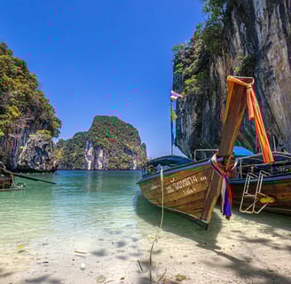 Krisa Travel Agent Krabi Tour boats in the water near a cliff