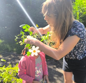 animatrice déposant une couronne végétale et florale sur la tête d'une petite fille