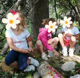 trois petites filles jouant sous un arbre lors d'un stage piano et nature à Lustin