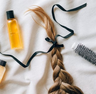 a bottle a brush and a braid of womens hair