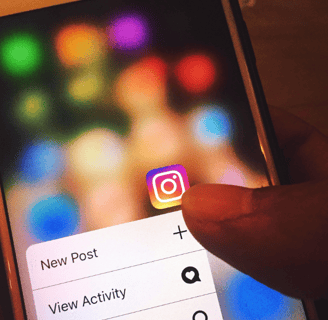 holding a phone which has Instagram logo