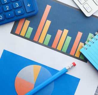 a pencil a calculator a notebook and a chart on the table