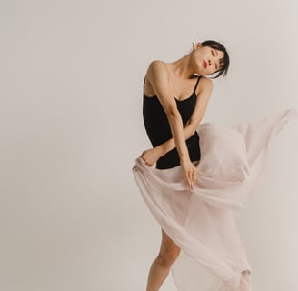 a girl in black top holding pink skirt