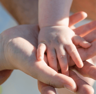 parents holding baby's hand