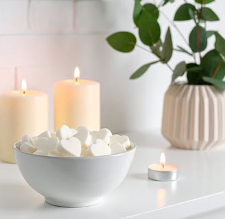 White heart wax melts in a white bowl situated in a contemporary white living space.
