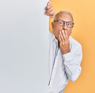 a man with glasses and a white shirt peeking out from the wall with a surprised expression.