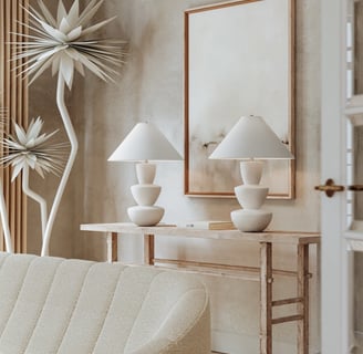 a living room with a couch and a table and white table lamps 