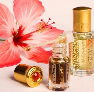 a bottle of perfume with a flower in the background explore  our attars at attarsouq