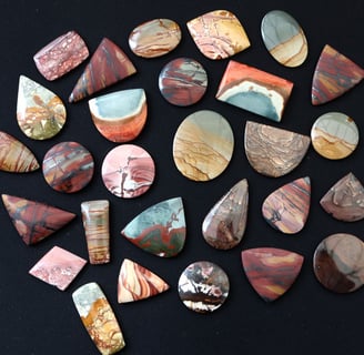 a large selection of hand cut scenic jasper cabochons in a variety of shapes