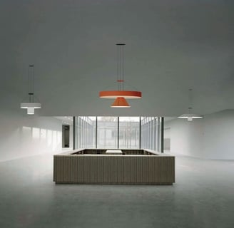 Lámparas técnicas suspendidas en espacio arquitectónico minimalista con luz natural