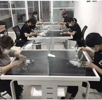 a group of people in a lab with a glass table