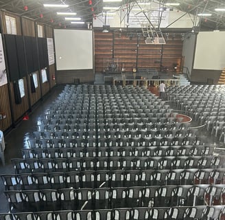a large room with rows of chairs and a projector