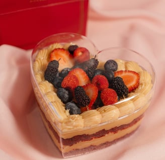 a heart shaped cake with fruit on top of it