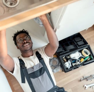 black man working under a sink