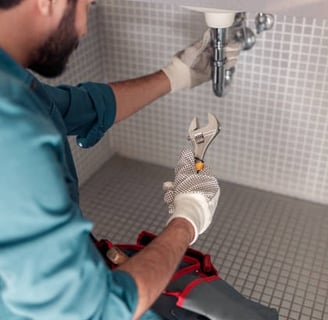 plumber aiming where he is going to slot his adjustable wrench to turn the pipe