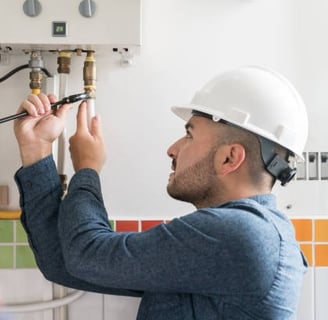 plumber tightening a pipe on a water heater