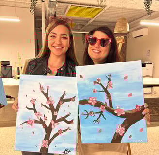 Participants fières de leurs œuvres après un atelier peinture EVJF