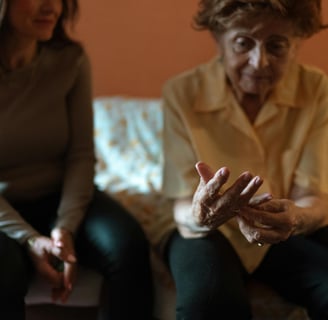 a woman sitting on a couch with her hands clasped to her chest