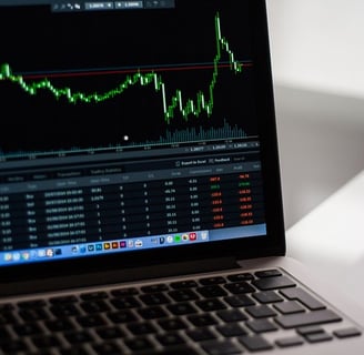 A laptop screen displaying a candlestick chart of a stock.