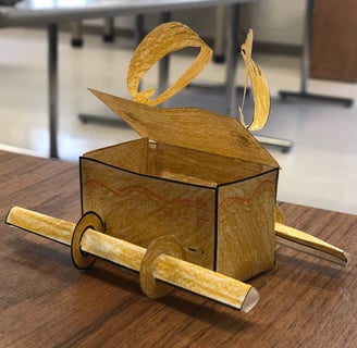 a paper model of the Ark of the Covenant on a desk in a classroom