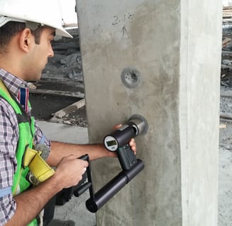 Ensayo no destructivo de resistencia en columna de concreto para evaluación estructural.