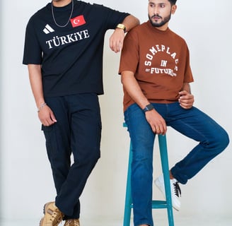 two men sitting on a stool in a room