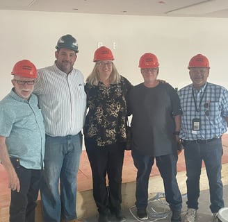DCC members wearing hard hats at Pah Apartments construction site