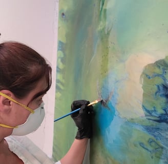 a woman in a mask and gloves is painting Parrot Spirit